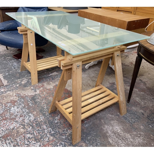 108 - An IKEA glass top desk on beech trestle supports - approx. 82cm high x 149cm wide x 79cm deep