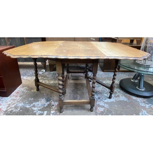 113 - An early 20th century oak pie crust edge drop leaf gate leg barley twist dining table - approx. 72cm... 