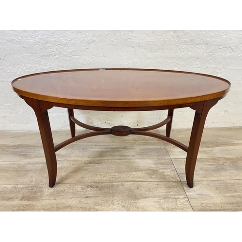 121 - A Regency style inlaid yew wood and mahogany oval coffee table - approx. 52cm high x 64cm wide x 112... 