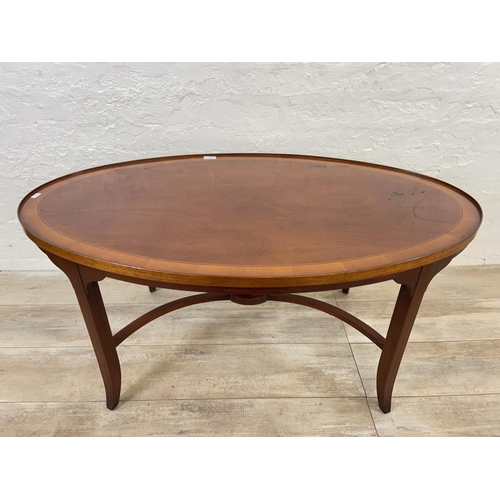 121 - A Regency style inlaid yew wood and mahogany oval coffee table - approx. 52cm high x 64cm wide x 112... 