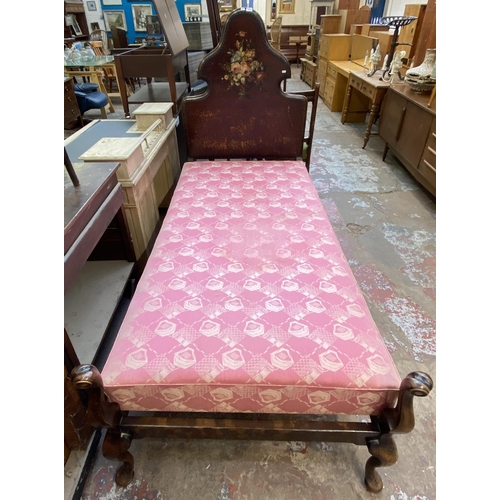 138 - An early 20th century beech single bed frame with hand painted floral design brown leather metal stu... 