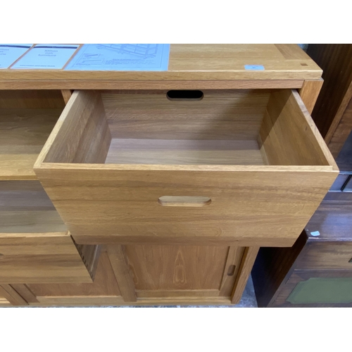 27 - A Laura Ashley Milton oak compartmental storage system - approx. 129cm high x 221cm wide x 40cm deep