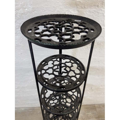 46 - A Victorian style black painted cast metal six tier pan stand on lion paw feet - approx. 123cm high