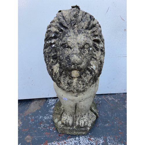 64 - A cast stone lion garden statue - approx. 52cm high