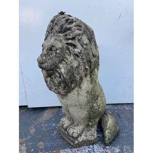 64 - A cast stone lion garden statue - approx. 52cm high