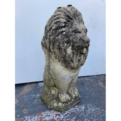 64 - A cast stone lion garden statue - approx. 52cm high