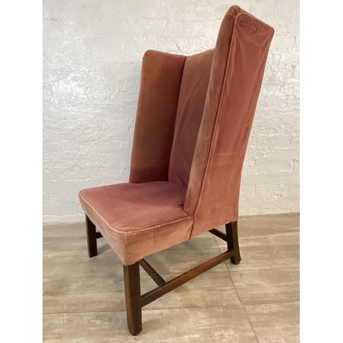 72C - A late 19th/early 20th century pink fabric upholstered high back porter's chair on mahogany supports... 