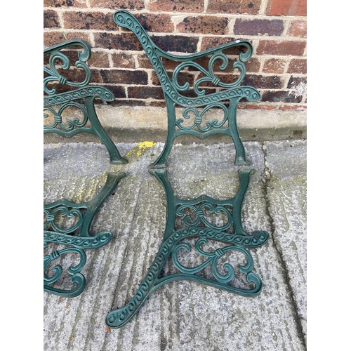 75 - Six green painted cast iron outdoor furniture accessories, two table legs and four bench ends