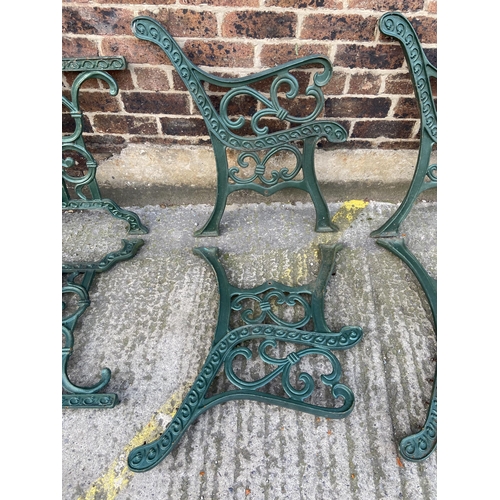 75 - Six green painted cast iron outdoor furniture accessories, two table legs and four bench ends