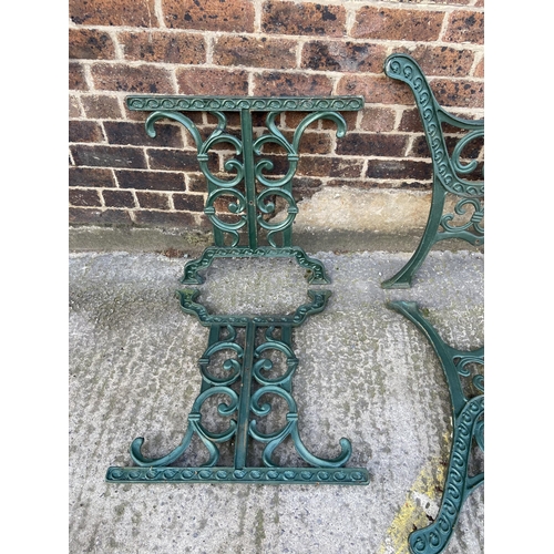 75 - Six green painted cast iron outdoor furniture accessories, two table legs and four bench ends