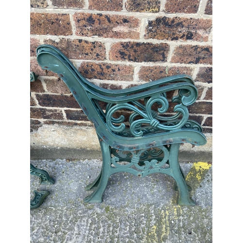 75 - Six green painted cast iron outdoor furniture accessories, two table legs and four bench ends