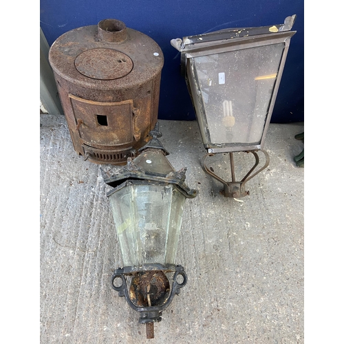 76 - Three outdoor items, one cast iron stove and two Victorian style lanterns