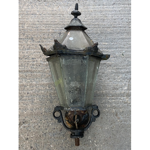 76 - Three outdoor items, one cast iron stove and two Victorian style lanterns