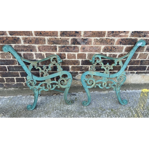 77 - A pair of green painted cast iron garden bench ends