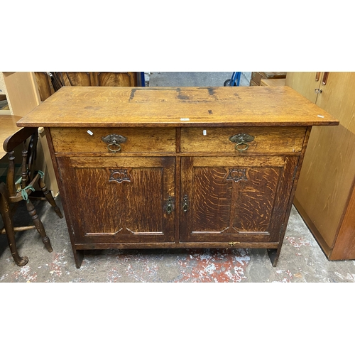 88 - An Arts & Crafts carved oak sideboard - approx. 97cm high x 137cm wide x 57cm deep