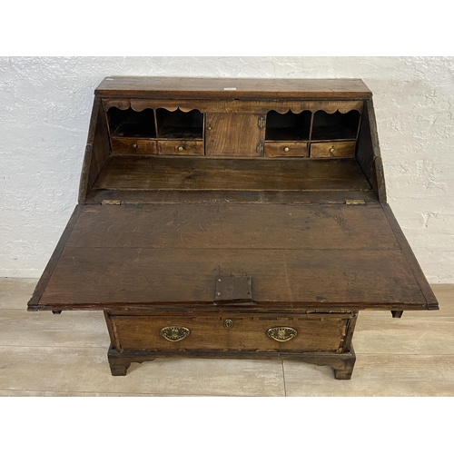 90 - A George III mahogany crossbanded and oak bureau - approx. 98cm high x 87cm wide x 46cm deep