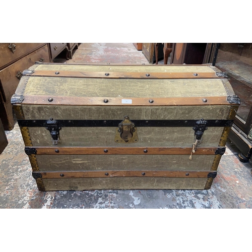 98 - An early 20th century green canvas and wooden banded dome top travel trunk - approx. 57cm high x 85c... 