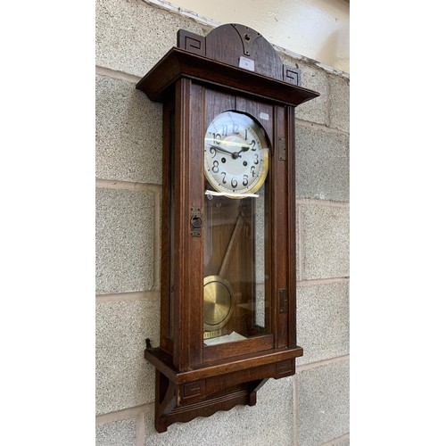 26 - An early 20th century oak cased chiming wall clock with pendulum and key - approx. 88cm high x 31cm ... 