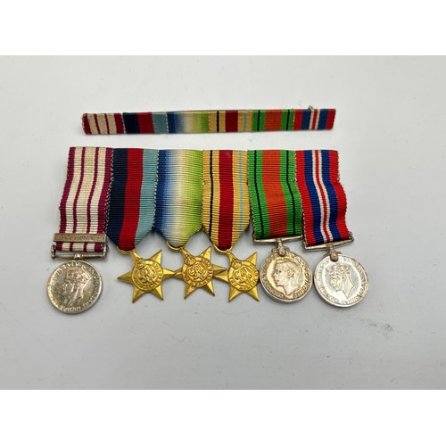 2361 - A collection of WWII British militaria, six piece medal group presented to Schlmr. J. F. Davidson. R... 