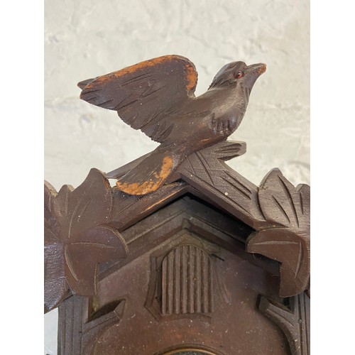 30 - A mid 20th century German carved wooden cased cuckoo clock with two weights - approx. 29cm high