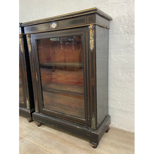 31 - A pair of 19th century ebonised and inlaid pier cabinets with gilt metal decoration and hand painted... 