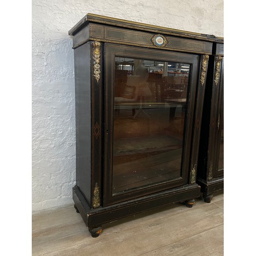 31 - A pair of 19th century ebonised and inlaid pier cabinets with gilt metal decoration and hand painted... 