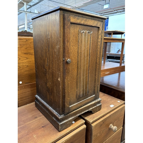 101 - A carved oak linenfold bedside cabinet - approx. 67cm high x 37cm wide x 65cm deep