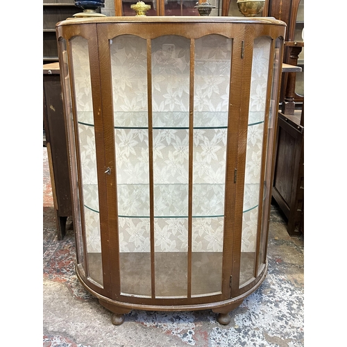 66 - A mid 20th century oak bow fronted display cabinet - approx. 118cm high x 90cm wide x 38cm deep