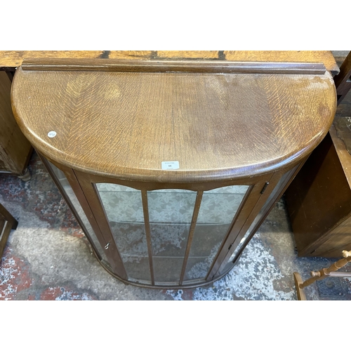 66 - A mid 20th century oak bow fronted display cabinet - approx. 118cm high x 90cm wide x 38cm deep