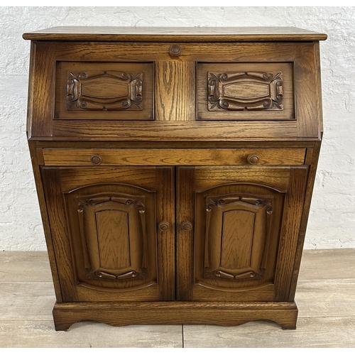 68 - A carved oak bureau - approx. 100cm high x 85cm wide x 43cm deep