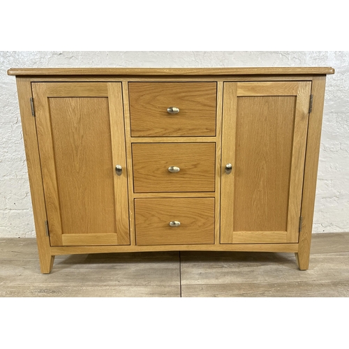 73 - A modern oak sideboard - approx. 81cm high x 114cm wide x 34cm deep