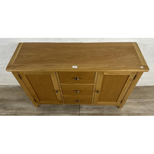 73 - A modern oak sideboard - approx. 81cm high x 114cm wide x 34cm deep