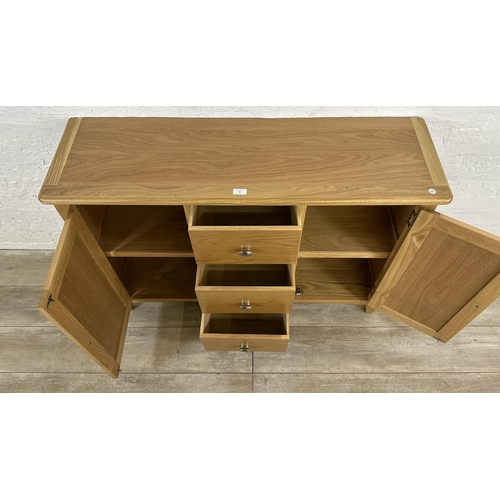 73 - A modern oak sideboard - approx. 81cm high x 114cm wide x 34cm deep