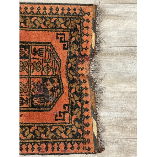 8 - A vintage Afghan orange and black rug - approx. 98cm x 65cm