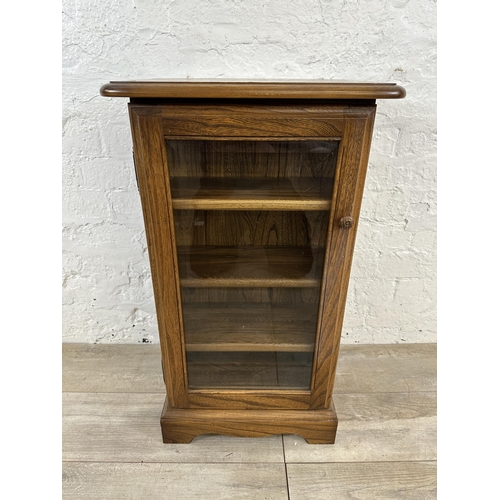 94 - An Ercol Golden Dawn elm CD cabinet - approx. 77cm high x 44cm wide x 38cm deep