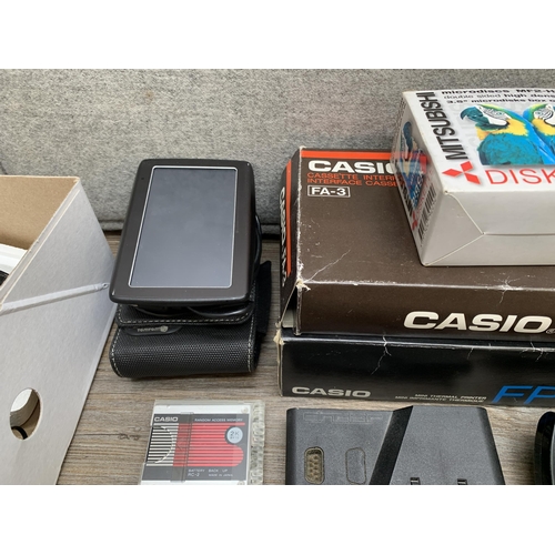 770 - A collection of items to include TomTom 4EN52 satnav, Mitsubishi MF2-HD microdiscs, Casio FP-12S min... 