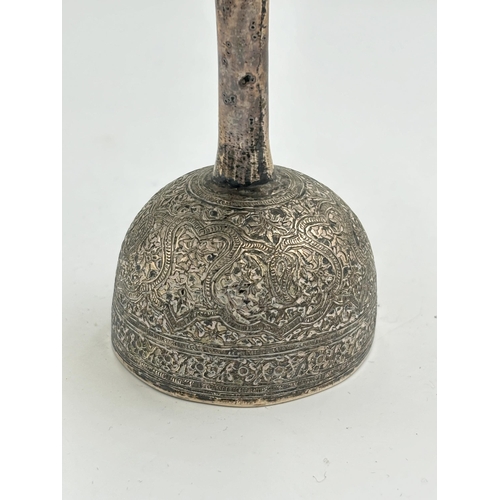 2160 - A late 19th century Indian white metal double peg spirit measure with detailed foliate chased design... 