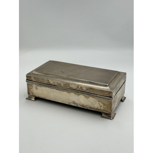 2163 - A hallmarked Birmingham silver rectangular presentation cigarette box on footed base, dated 1929 -ap... 