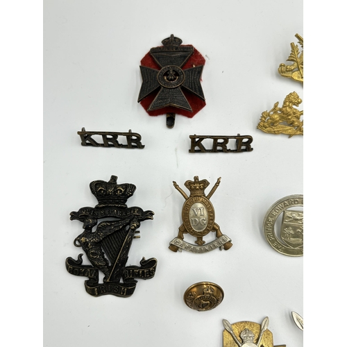 2292 - A collection of military cap badges, shoulder titles and buttons to include Kenya Police, British So... 