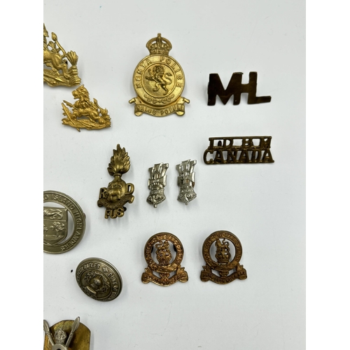 2292 - A collection of military cap badges, shoulder titles and buttons to include Kenya Police, British So... 