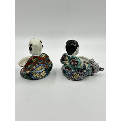 319 - Two Oriental hand painted porcelain figurines of a boy and girl holding clam shells - approx. 13cm h... 