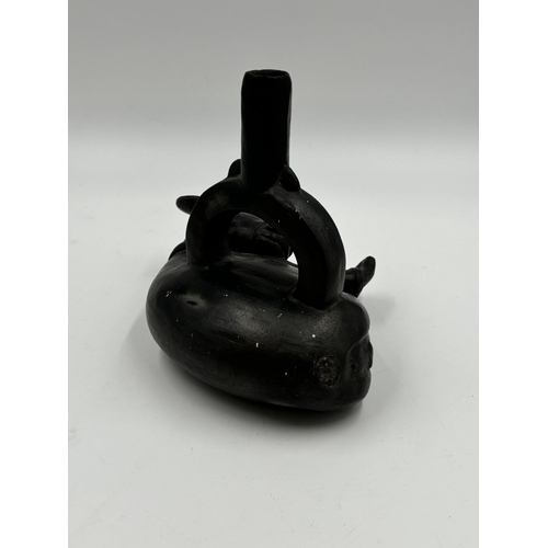 320 - A Chimu Blackware pottery stirrup vessel in the form of a bound deer - 17cm high