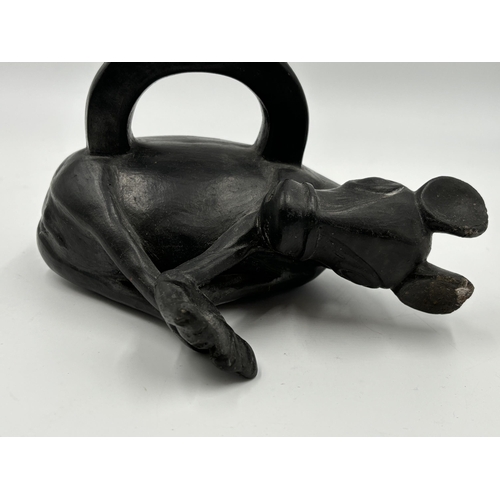 320 - A Chimu Blackware pottery stirrup vessel in the form of a bound deer - 17cm high