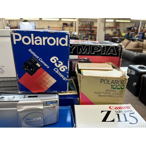 731 - A collection of boxed cameras to include Olympus Superzoom 70G, Canon Sureshot Z115, Olympus Shoot &... 