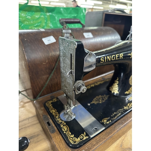 822 - A cased 1934 Singer 128K hand-crank sewing machine with a bag containing patterns