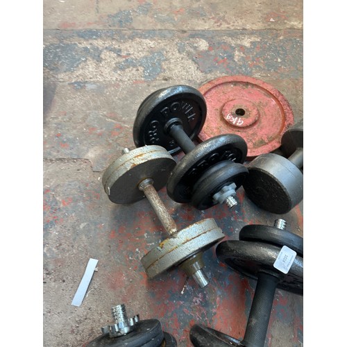 1024 - A collection of weight lifting equipment to include dumbbells, various weighted plates etc.