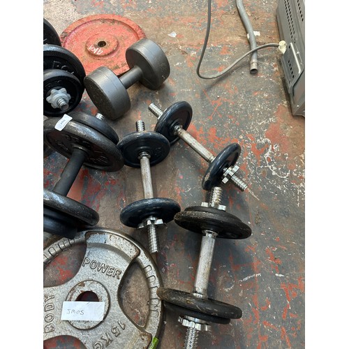 1024 - A collection of weight lifting equipment to include dumbbells, various weighted plates etc.