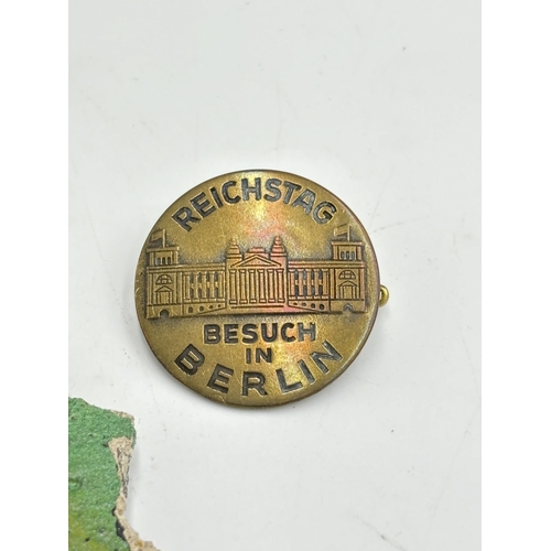 2298 - Two items, one German Reichstag visit in Berlin brass badge and one piece of the Berlin wall