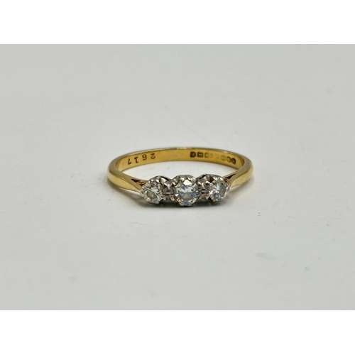 2133J - A hallmarked 18ct gold three stone diamond ring, size O - approx. gross weight 2.6g