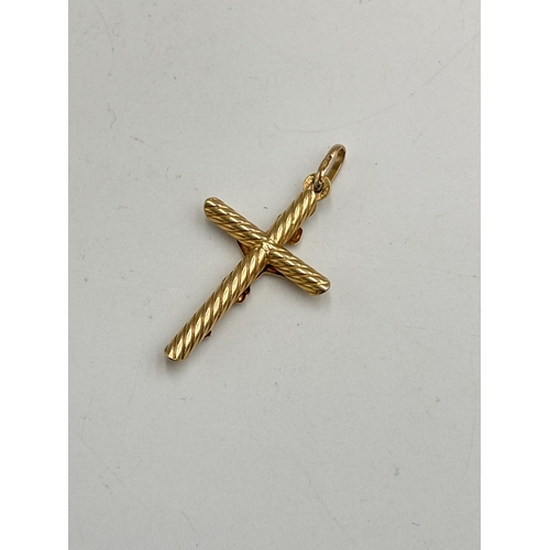 2134B - A 9ct gold crucifix pendant - approx. gross weight 2g